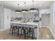 Bright kitchen featuring a large island with marble countertop, white cabinets, and modern pendant lighting fixtures at 2326 Guilford Ave, Indianapolis, IN 46205