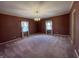Large bedroom featuring carpeting, textured wallpaper, a chandelier, and two windows with curtains at 2365 E 850 N, Lebanon, IN 46052