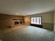 Spacious living room featuring a brick fireplace, large window, and neutral carpeting at 2365 E 850 N, Lebanon, IN 46052