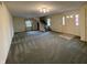 Spacious living room features staircase, carpeting, two windows with curtains, and white front door at 2365 E 850 N, Lebanon, IN 46052