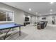 Finished basement featuring a ping pong table, large TV, comfortable leather sofa, and egress window at 2798 W High Grove Cir, Zionsville, IN 46077