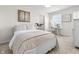 A well-lit bedroom featuring neutral tones, a comfortable bed, and a dedicated workspace by the window at 2798 W High Grove Cir, Zionsville, IN 46077