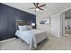 Bedroom with stylish accent wall and artwork, a comfortable bed, and a door leading to other areas at 2798 W High Grove Cir, Zionsville, IN 46077
