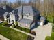 Aerial view of a brick and stone home with an attached garage, long driveway, and green lawn at 2798 W High Grove Cir, Zionsville, IN 46077