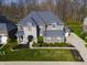 Aerial view of a brick and stone home with an attached garage, long driveway, and green lawn at 2798 W High Grove Cir, Zionsville, IN 46077