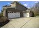 Three-car garage with white doors and an expansive driveway, providing ample parking and storage space at 2798 W High Grove Cir, Zionsville, IN 46077