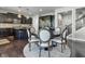 Open eat-in kitchen with round table and chairs, dark cabinetry, and stainless steel appliances at 2798 W High Grove Cir, Zionsville, IN 46077
