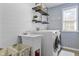 Well-lit laundry room with modern washer/dryer, utility sink and ample shelving at 2798 W High Grove Cir, Zionsville, IN 46077