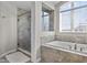 A bathroom featuring a glass-enclosed shower, soaking tub, and a large arched window allowing natural light at 2798 W High Grove Cir, Zionsville, IN 46077