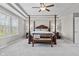 Bright primary bedroom with tray ceilings, neutral carpet, and a four-poster bed at 2798 W High Grove Cir, Zionsville, IN 46077