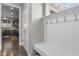 Mudroom features coat hooks, bench seating, and storage space with kitchen view in the background at 2798 W High Grove Cir, Zionsville, IN 46077