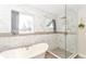 Modern bathroom featuring a soaking tub, tiled walls, and a glass-enclosed shower at 2945 N New Jersey St, Indianapolis, IN 46205