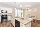 This is a kitchen with granite countertops, hardwood floors, white cabinets, stainless steel appliances, and a dining area at 2945 N New Jersey St, Indianapolis, IN 46205