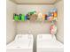 Functional laundry room with stacked washer and dryer and shelving above for storage at 2945 N New Jersey St, Indianapolis, IN 46205