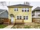 Back exterior of a two-story home with a small deck, tidy yard, and lots of windows at 3133 Ruckle St, Indianapolis, IN 46205