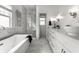 Modern bathroom with a soaking tub, walk-in shower, double sink vanity, and marble tile at 3133 Ruckle St, Indianapolis, IN 46205