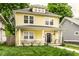 Inviting yellow two-story home with a cozy front porch, showcasing curb appeal and charm at 3133 Ruckle St, Indianapolis, IN 46205