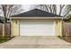 Detached two car garage with clean white door, exterior lights and driveway at 3133 Ruckle St, Indianapolis, IN 46205