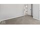 Bedroom features plush carpet and natural light, leading to a connected kitchen at 338 S Roena St, Indianapolis, IN 46241