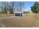 View of detached garage with dark gray door and gray siding in a fenced backyard at 338 S Roena St, Indianapolis, IN 46241