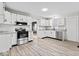 Bright kitchen featuring white cabinets, stainless steel appliances, and new flooring at 338 S Roena St, Indianapolis, IN 46241