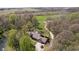 A high aerial view of the brown-roofed home with a pond and outbuildings nestled within trees at 3718 S County Road 101 E, Clayton, IN 46118