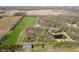 Aerial view of property with pond and home with surrounding fields and trees, offering privacy and space at 3718 S County Road 101 E, Clayton, IN 46118