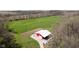 Aerial view of red barn featuring a white roof nestled in a green meadow with surrounding trees at 3718 S County Road 101 E, Clayton, IN 46118