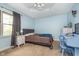 Comfortable bedroom with blue accent wall, a bed with upholstered headboard, and a ceiling fan at 3718 S County Road 101 E, Clayton, IN 46118