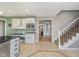 Spacious kitchen with tile flooring, white cabinets, black countertops and adjacent stairs at 3718 S County Road 101 E, Clayton, IN 46118