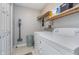 Functional laundry room with a washer, dryer, shelving, and tiled flooring for convenience at 3718 S County Road 101 E, Clayton, IN 46118