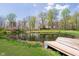Beautiful pond reflecting the home and mature trees on a partly cloudy day, dock feature at 3718 S County Road 101 E, Clayton, IN 46118