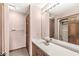 Pink bathroom with a large mirror, white countertops and cabinetry, wood trim and a walk-in shower at 3748 Bay Rd S Dr, Indianapolis, IN 46240