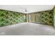 Beautiful bedroom with banana leaf wallpaper, ceiling fan, and sliding glass doors to backyard at 3748 Bay Rd S Dr, Indianapolis, IN 46240