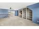 Spacious bonus room with blue walls, built-in bookshelves, and ceiling fan at 3748 Bay Rd S Dr, Indianapolis, IN 46240
