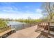 Relax on the wooden deck featuring a hot tub and bench seating, all while enjoying serene views of the lake at 3748 Bay Rd S Dr, Indianapolis, IN 46240