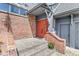 Inviting brick home with an orange double-door entrance, stone steps and a charming flower pot at 3748 Bay Rd S Dr, Indianapolis, IN 46240