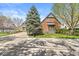 Charming two-story brick home with mature trees, manicured lawn, and an asphalt driveway at 3748 Bay Rd S Dr, Indianapolis, IN 46240