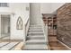 View of the carpeted staircase, white railing, and decorative brick wall with built-in shelves at 3748 Bay Rd S Dr, Indianapolis, IN 46240