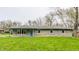 Charming single story home showcasing a stone facade and well-manicured lawn and bright blue trim at 3959 N Grant Ave, Indianapolis, IN 46226