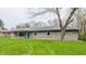 Charming single story home showcasing a stone facade and well-manicured lawn and bright blue trim, with mature trees at 3959 N Grant Ave, Indianapolis, IN 46226