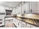 The kitchen has marbled countertops, stainless steel appliances, and wooden cabinets at 3959 N Grant Ave, Indianapolis, IN 46226