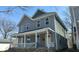 Two story home with a grey exterior and a covered front porch with white trim and railing at 437 Jefferson Ave, Indianapolis, IN 46201
