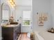 Cozy bathroom featuring a vanity with double mirrors, a soaking tub, and natural light from the window at 4417 Barharbor Ct, Indianapolis, IN 46268