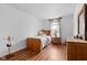 Cozy bedroom features wood flooring, a wooden twin bed, and bright natural light from the window at 4417 Barharbor Ct, Indianapolis, IN 46268