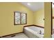Bathroom with soaking tub, window, and wood trim at 4606 Sundance Trl, Indianapolis, IN 46239