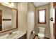 Cozy half bathroom with a marble sink top, wood trim, and a window providing natural light at 4606 Sundance Trl, Indianapolis, IN 46239