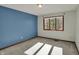 Bedroom featuring large window, blue accent wall, and neutral carpet at 4606 Sundance Trl, Indianapolis, IN 46239