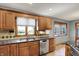 Traditional kitchen featuring wood cabinetry, stainless steel appliances, and a double-basin sink at 4606 Sundance Trl, Indianapolis, IN 46239