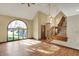 Bright living room featuring hardwood floors, a staircase, and an expansive arched window at 4606 Sundance Trl, Indianapolis, IN 46239